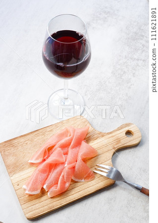 Drink red wine with salty and delicious prosciutto as a snack. Drink red wine with salty and delicious prosciutto as a snack. 111621891