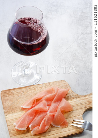 喝紅酒配鹹味可口的火腿當零食。 喝紅酒配鹹味可口的火腿當零食。 111621892