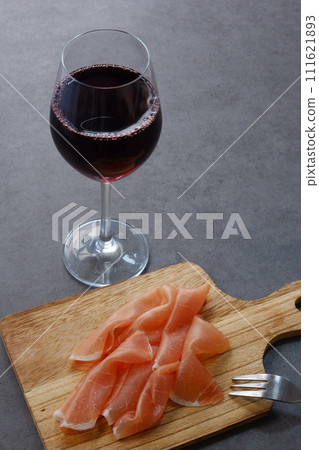 Drink red wine with salty and delicious prosciutto as a snack. Drink red wine with salty and delicious prosciutto as a snack. 111621893