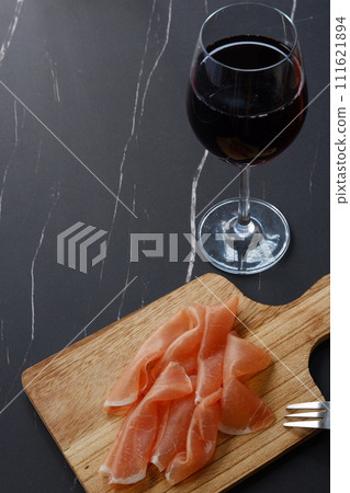 Drink red wine with salty and delicious prosciutto as a snack. 111621894