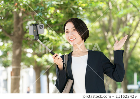 穿著西裝的女人用智慧型手機自拍 穿著西裝的女人用智慧型手機自拍 111622429