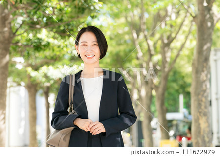 一個30多歲的女人穿著西裝在新綠色微笑 111622979