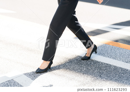 Feet of a woman crossing a pedestrian crossing 111623293