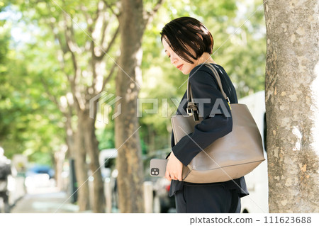 穿著西裝的女人用智慧型手機秘密拍照 穿著西裝的女人用智慧型手機秘密拍照 111623688