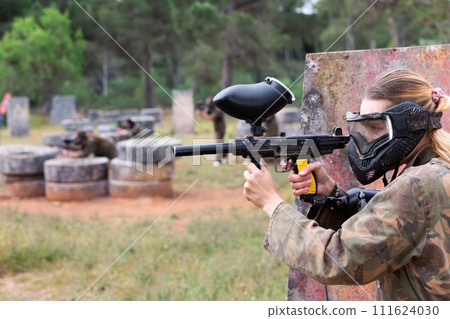 Portrait of girl in camouflage on paintball field 111624030