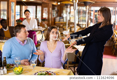 Woman quarreling with her husband and mistress in restaurant 111624096