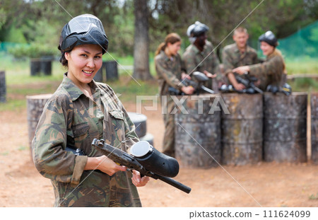 Portrait of asian female with gun on paintball field 111624099