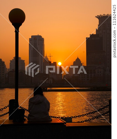 Skyscrapers on the Huangpu River bathed in the setting sun, vertical composition Skyscrapers on the Huangpu River bathed in the setting sun, vertical composition 111624425