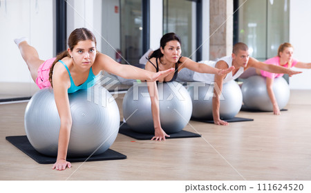 Young adults training pilates at group class Young adults training pilates at group class 111624520