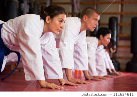 Training group of athletes before karate training - push-ups and muscle warm-up 111624611