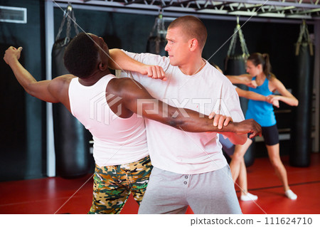 Men and women exercising during self-protection training Men and women exercising during self-protection training 111624710