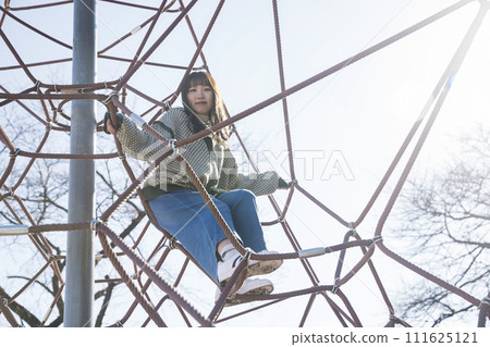 年輕女子攀登繩索叢林健身房 年輕女子攀登繩索叢林健身房 111625121