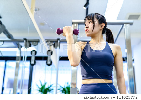 年輕女子在私人健身房訓練身體,啞鈴彎舉,二頭肌,肌肉訓練女孩,顯然 年輕女子在私人健身房訓練身體,啞鈴彎舉,二頭肌,肌肉訓練女孩,顯然 111625772