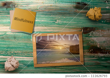 Stack of paper with mindfulness text and a small chalkboard with a nature view Stack of paper with mindfulness text and a small chalkboard with a nature view 111626793