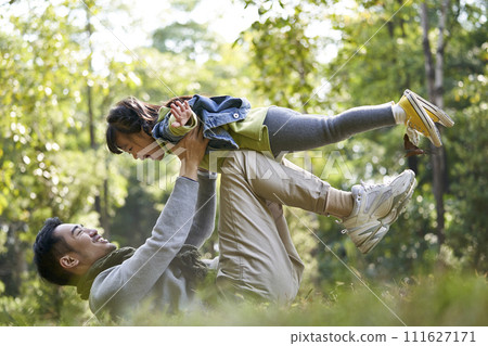 young asian father and daughter having a good time outdoors in park 111627171