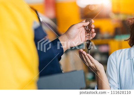 Mechanic car dealer giving car key to customer for finished car service fix problem or auto sell deal Mechanic car dealer giving car key to customer for finished car service fix problem or auto sell deal 111628110