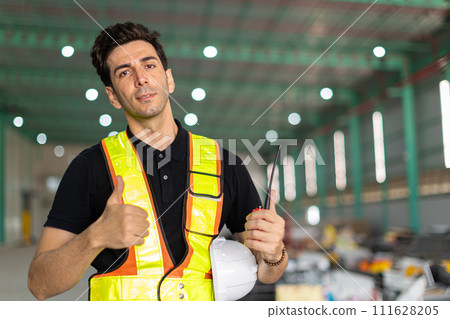 Engineer man hand like sign or factory worker wear safety helmet in warehouse site indoor Showing thumbs up happy smile.Good working finished job done. 111628205