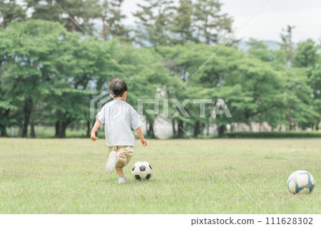 孩子們和男孩在公園的草地上踢足球（足球運球） 111628302