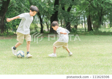 Brothers, friends, and boys playing soccer on the grass in the park (soccer ball and dribbling) 111628306