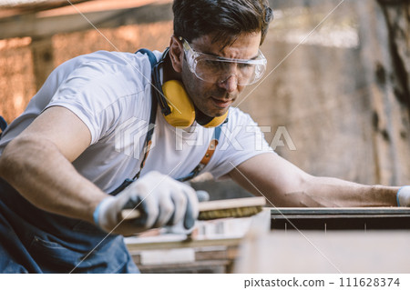 Carpenter man attend to making masterpiece woodworks handcrafted fine detail make wooden furniture in wood workshop. Carpenter man attend to making masterpiece woodworks handcrafted fine detail make wooden furniture in wood workshop. 111628374