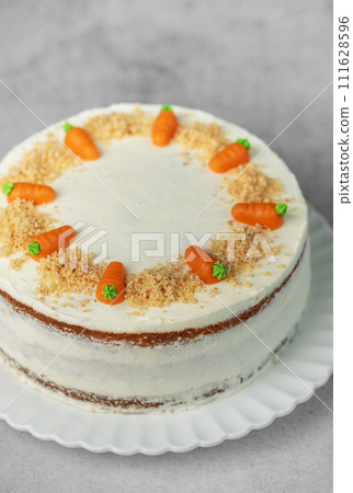 Homemade carrot cake made with walnuts, iced with cream cheese. Sweet dessert. 111628596