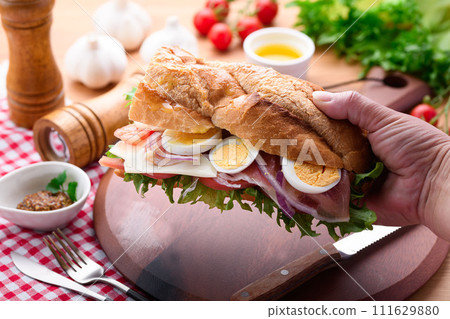 Baguette sandwich with plenty of toppings Baguette sandwich with plenty of toppings 111629880