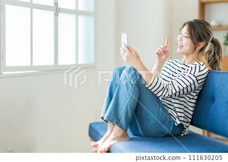 一名年輕女子正在操作智慧型手機。 一名年輕女子正在操作智慧型手機。 111630205