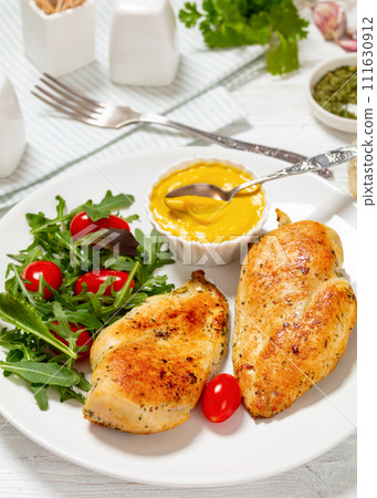fried chicken breasts with green salad on plate fried chicken breasts with green salad on plate 111630912