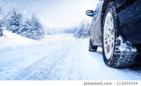 Car tires on winter road covered with snow close-up Car tires on winter road covered with snow close-up 111634334
