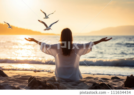 Young woman meditating on the beach 111634434
