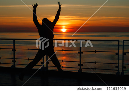 Girl silhouette in magical sunset over the Gulf of Finland, Baltic sea. 111635019