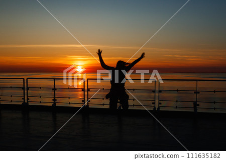 Girl silhouette in magical sunset over the Gulf of Finland, Baltic sea. 111635182