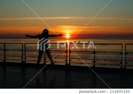 Girl silhouette in magical sunset over the Gulf of Finland, Baltic sea. 111635183