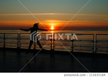 Girl silhouette in magical sunset over the Gulf of Finland, Baltic sea. 111635184