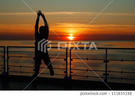 Girl silhouette in magical sunset over the Gulf of Finland, Baltic sea. 111635188