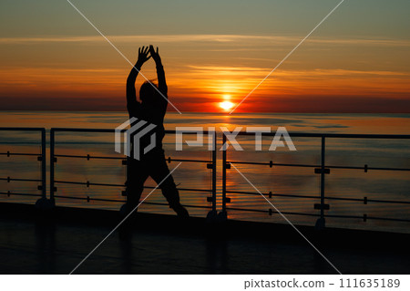 Girl silhouette in magical sunset over the Gulf of Finland, Baltic sea. 111635189