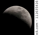 A waxing moon floating in the late autumn night sky 111635416