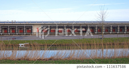 Row of loading docks with shutter doors at an industrial warehouse Row of loading docks with shutter doors at an industrial warehouse 111637586