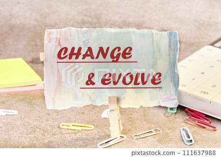 The text CHANGE EVOLVE written on a piece of paper in a clothespin 111637988
