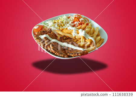 Floating plate with Kefta meat and french fries on red gradient Floating plate with Kefta meat and french fries on red gradient 111638339