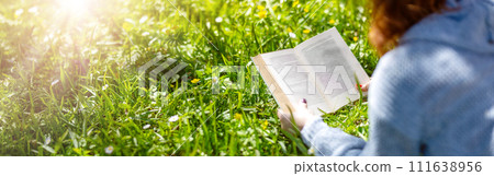 Young woman lying on the field and reading a book. Young woman lying on the field and reading a book. 111638956