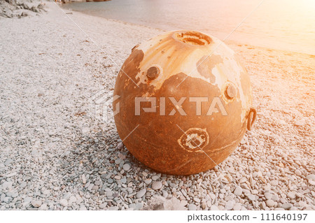 Old rusty sea mine on the beach. 111640197
