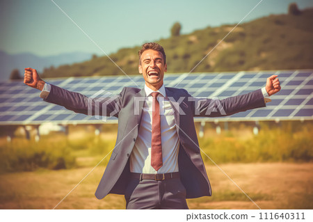 a joyful businessman jumping with excitement against the backdrop of solar panels. 111640311