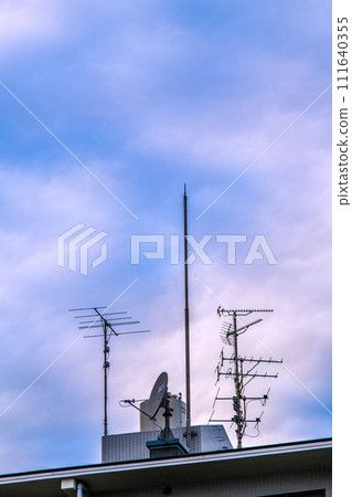 日本東京城市景觀 安裝在公寓大樓屋頂上的天線和雲彩...未來的電視將是什麼... 111640355