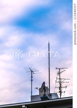 日本東京城市景觀 安裝在公寓大樓屋頂上的天線和雲彩...未來的電視將是什麼... 111640357