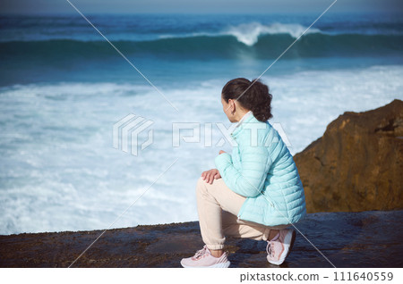 Woman, adventurer traveler tourist looking into the distance, standing on the cliff overlooking Atlantic ocean Woman, adventurer traveler tourist looking into the distance, standing on the cliff overlooking Atlantic ocean 111640559