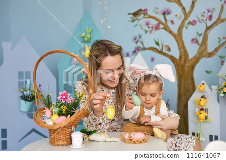 Happy holiday. Mother and her daughter with painting eggs. Happy holiday. Mother and her daughter with painting eggs. 111641067