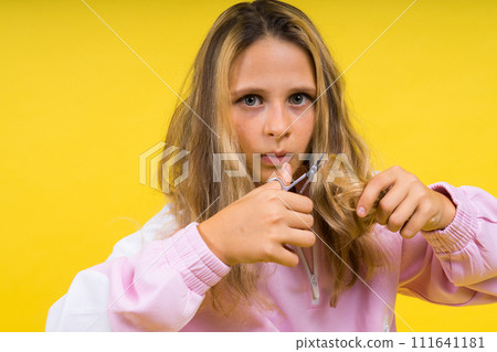 Cheerful kid cut long hair, casual fashion style for beautiful child, girl use hairdresser scissors. Cheerful kid cut long hair, casual fashion style for beautiful child, girl use hairdresser scissors. 111641181