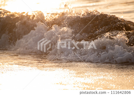 waves lit by the setting sun 111642806