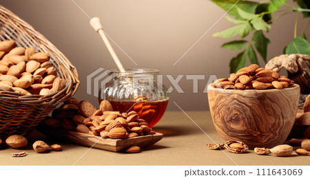 Almond nuts and honey on a brown background. 111643069